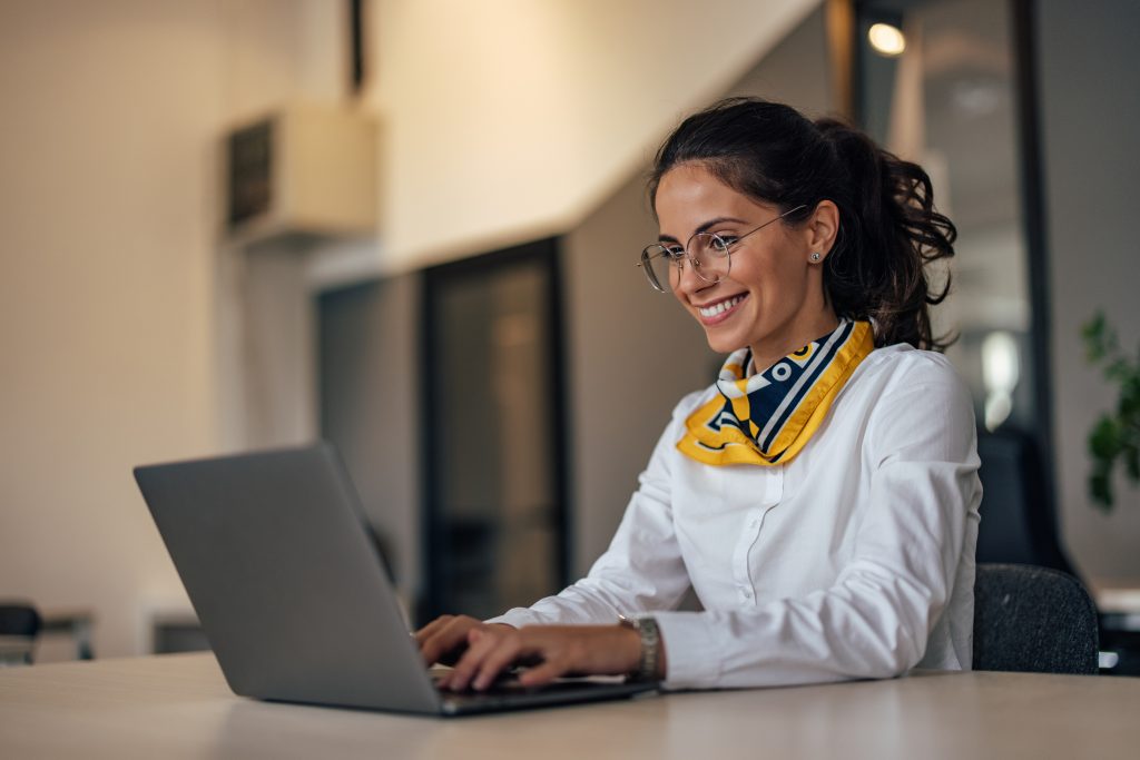 Content Creatorin sitzt am Laptop
